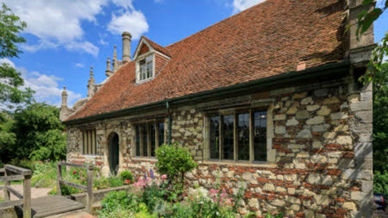 The entrance door to Bourne Mill, with a path leading to the door and floors in the border